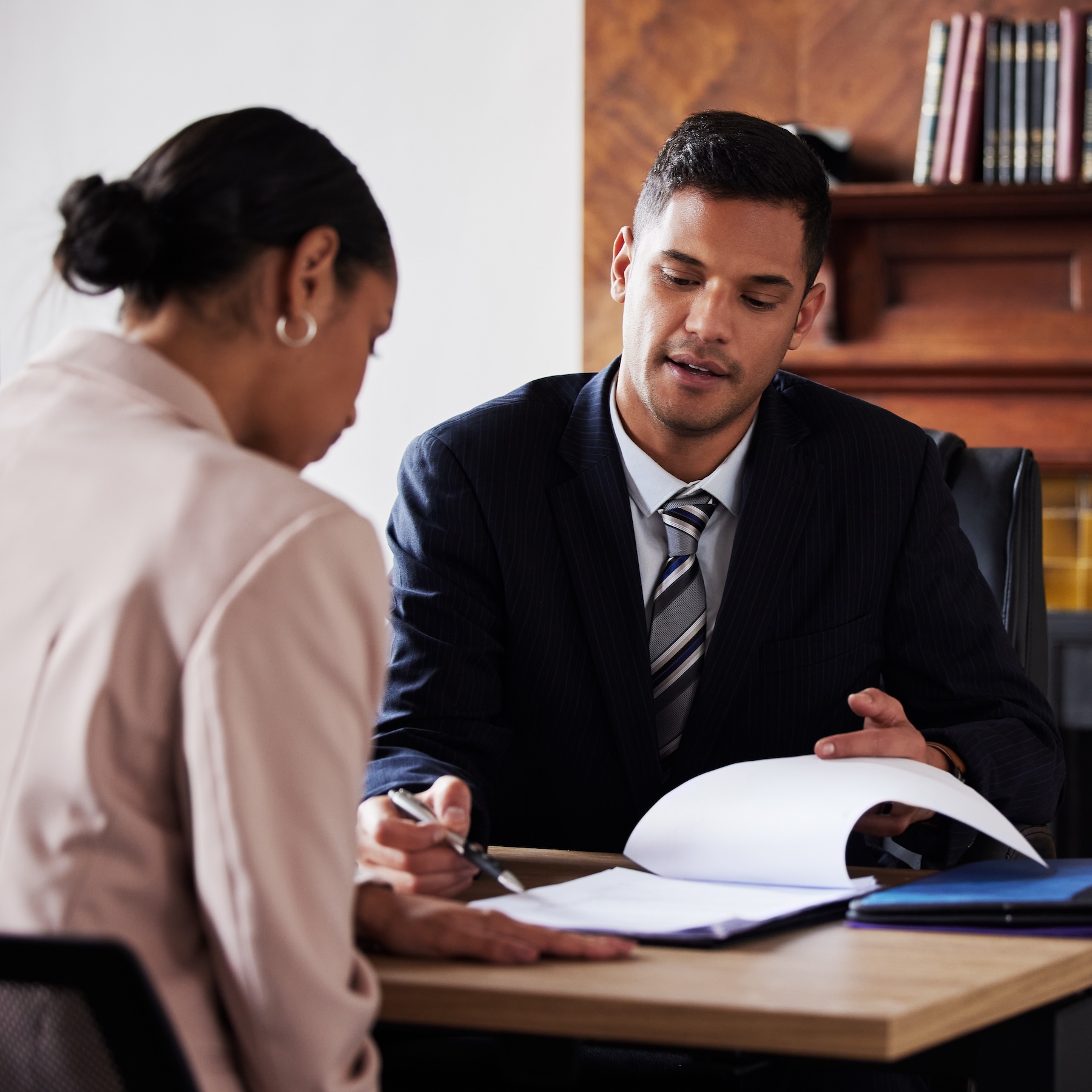 Client signing contract while consulting with a lawyer in his office